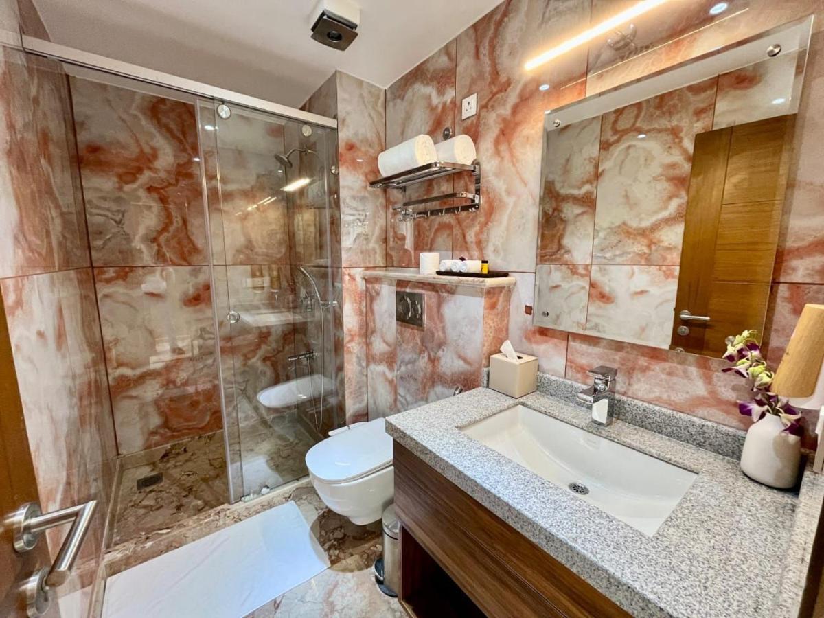 a bathroom with a sink and a shower and a toilet at The Prominence Mussoorie Road Dehradun in Dehradun