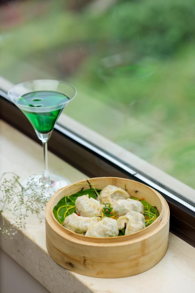 a drink and a bowl of dumplings and a glass at The Prominence Mussoorie Road Dehradun in Dehradun