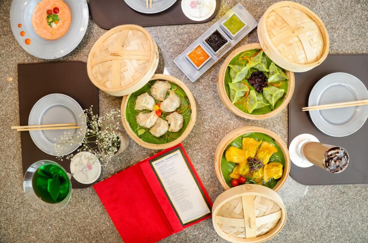 a table with plates of food and a book at The Prominence Mussoorie Road Dehradun in Dehradun