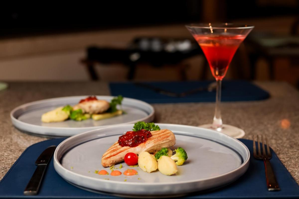 two plates of food on a table with a drink at The Prominence Mussoorie Road Dehradun in Dehradun