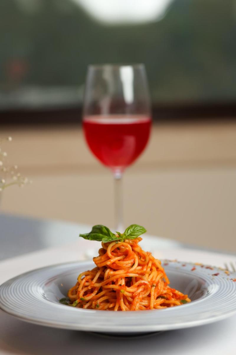a plate of pasta and a glass of red wine at The Prominence Mussoorie Road Dehradun in Dehradun