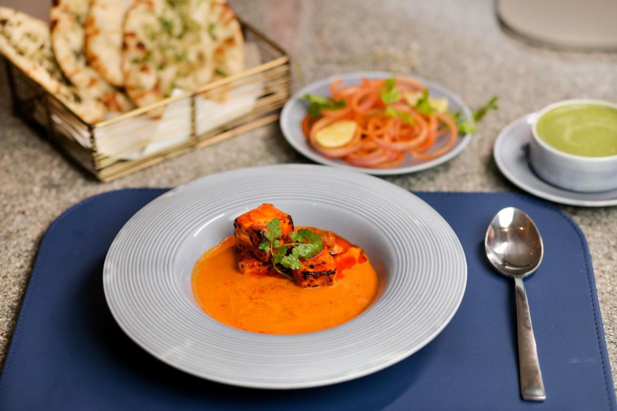 a plate of food on a table with a bowl of soup at The Prominence Mussoorie Road Dehradun in Dehradun