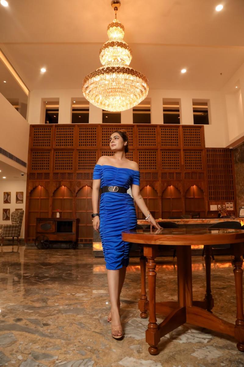a woman in a blue dress standing next to a table at The Prominence Mussoorie Road Dehradun in Dehradun
