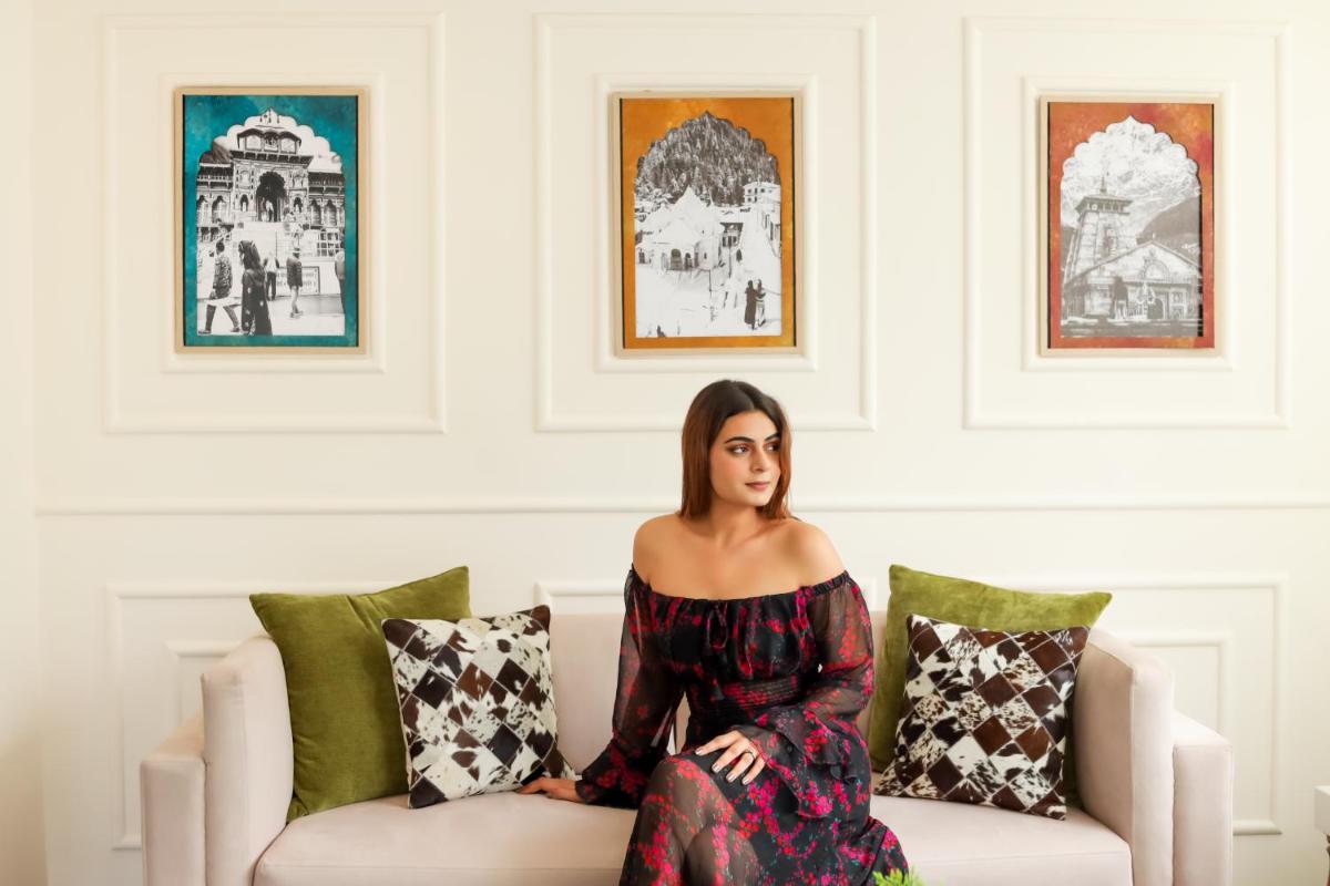 a woman in a dress sitting on a couch at The Prominence Mussoorie Road Dehradun in Dehradun