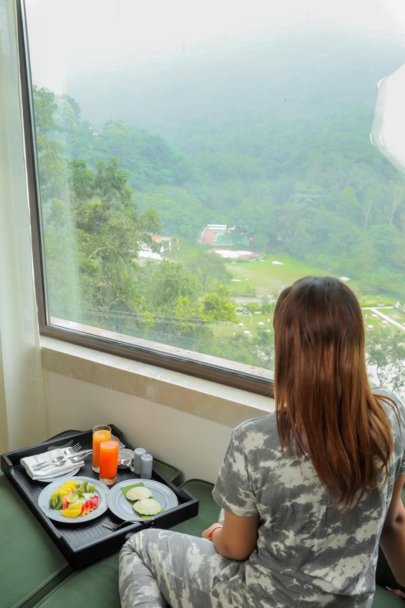 a woman sitting in a train with a tray of food at The Prominence Mussoorie Road Dehradun in Dehradun