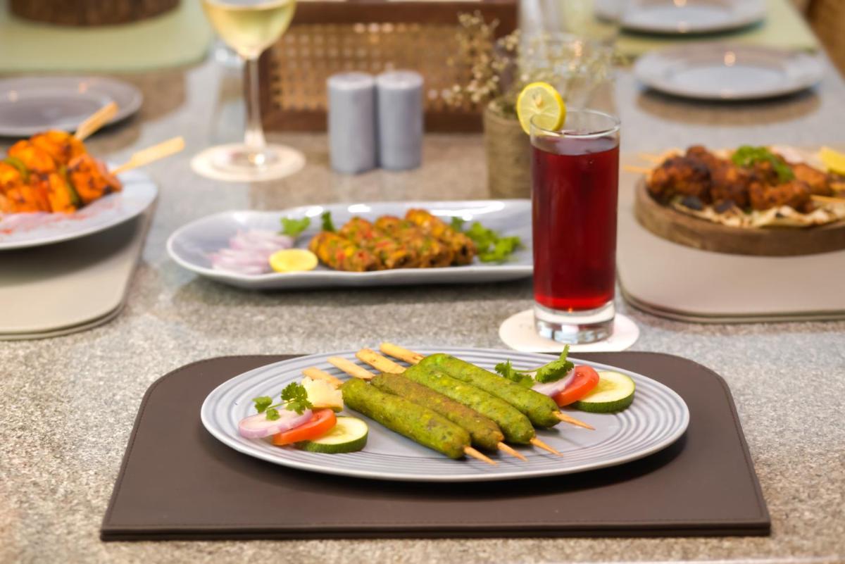 a table with plates of food and a drink at The Prominence Mussoorie Road Dehradun in Dehradun