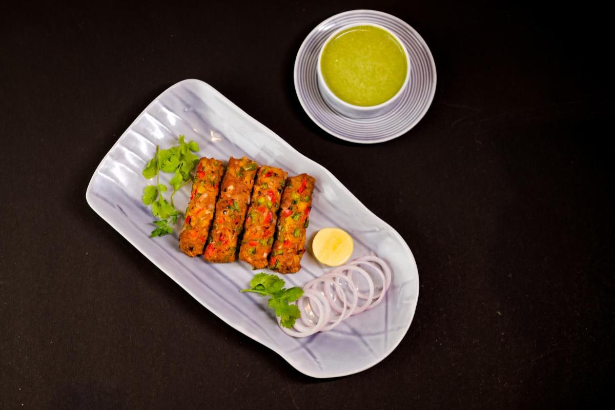 a plate of food with carrots and a bowl of sauce at The Prominence Mussoorie Road Dehradun in Dehradun