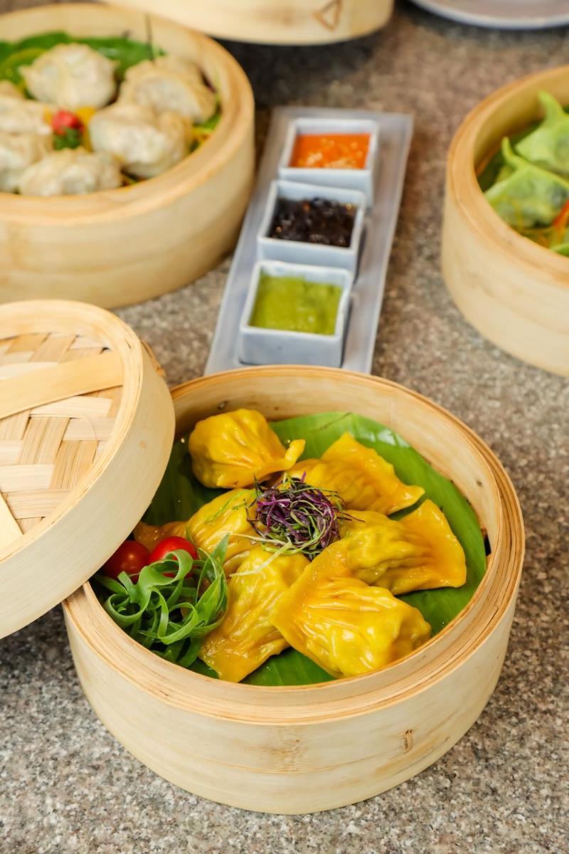 a wooden bowl filled with vegetables on a table at The Prominence Mussoorie Road Dehradun in Dehradun
