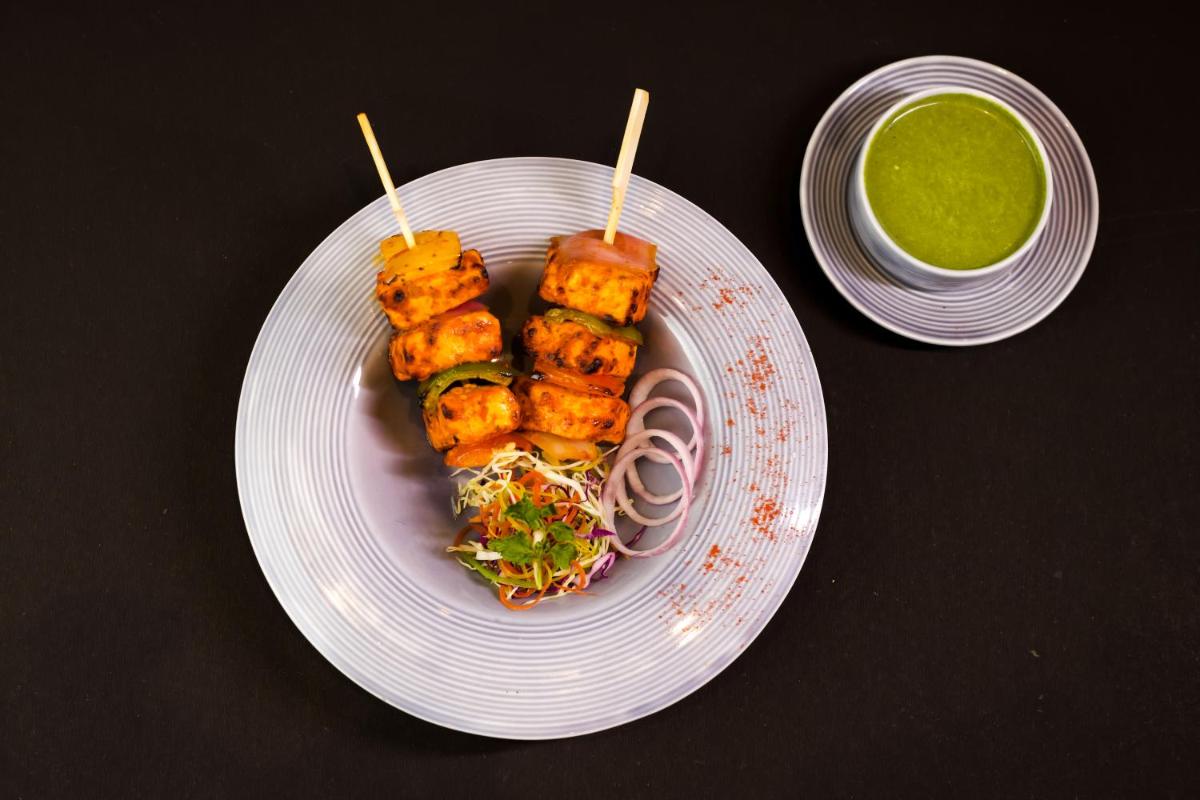 a plate with tofu skewers on a table with green sauce at The Prominence Mussoorie Road Dehradun in Dehradun