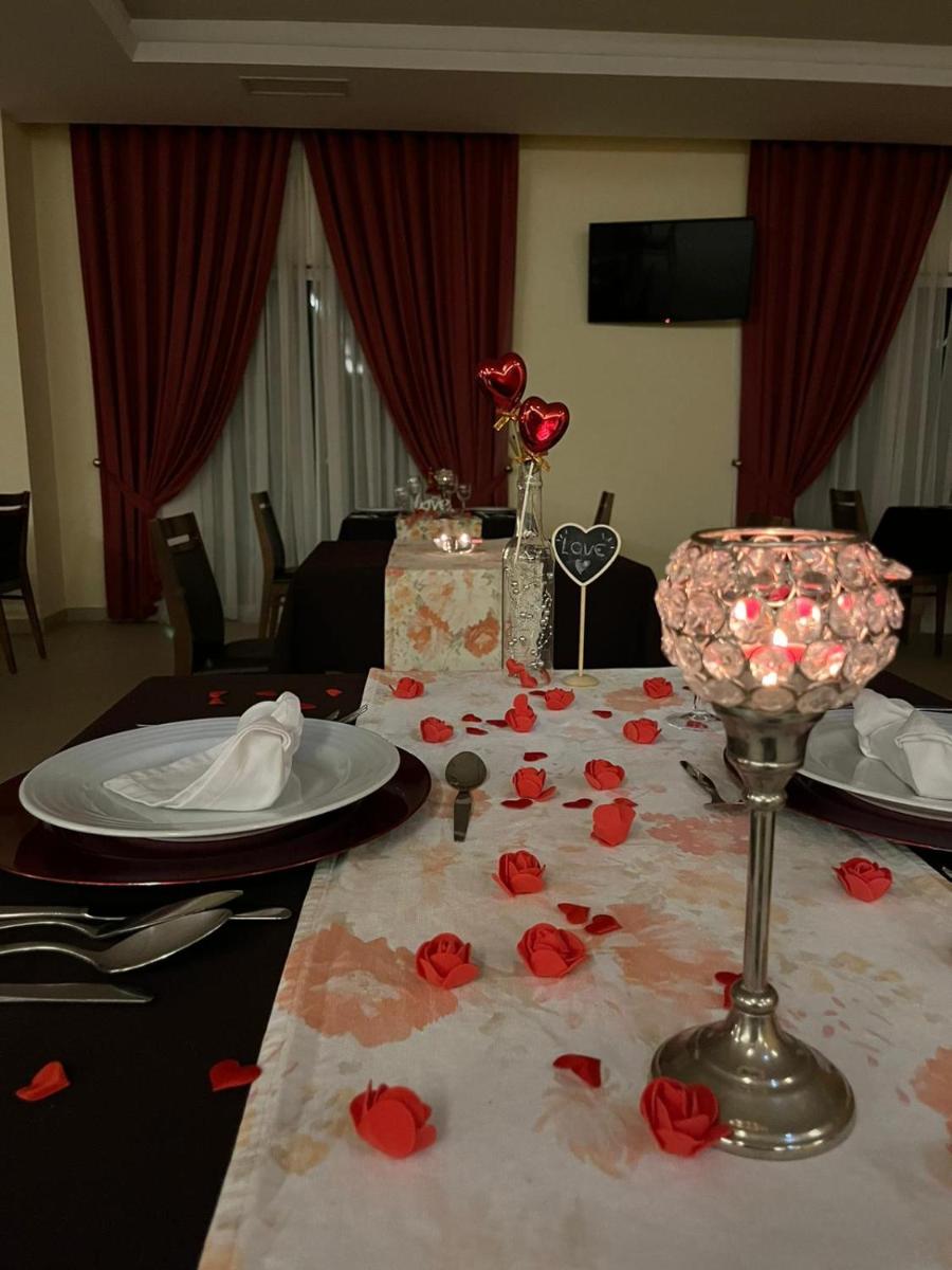 uma mesa coberta com rosas vermelhas em cima de uma mesa em Palace Hotel & SPA Termas do Bicanho em Soure mais 28 fotografias