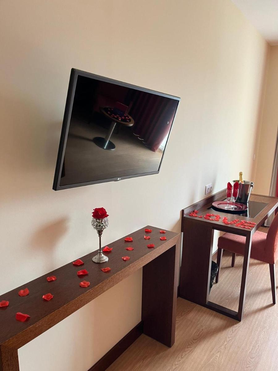 um quarto com uma mesa com rosas vermelhas em Palace Hotel & SPA Termas do Bicanho em Soure