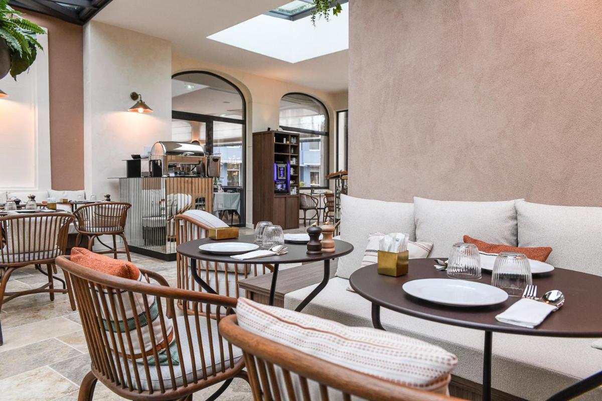un restaurant avec des tables, des chaises et un canapé dans l'établissement Grand Hôtel Du Parc - Teritoria, à Aix-les-Bains