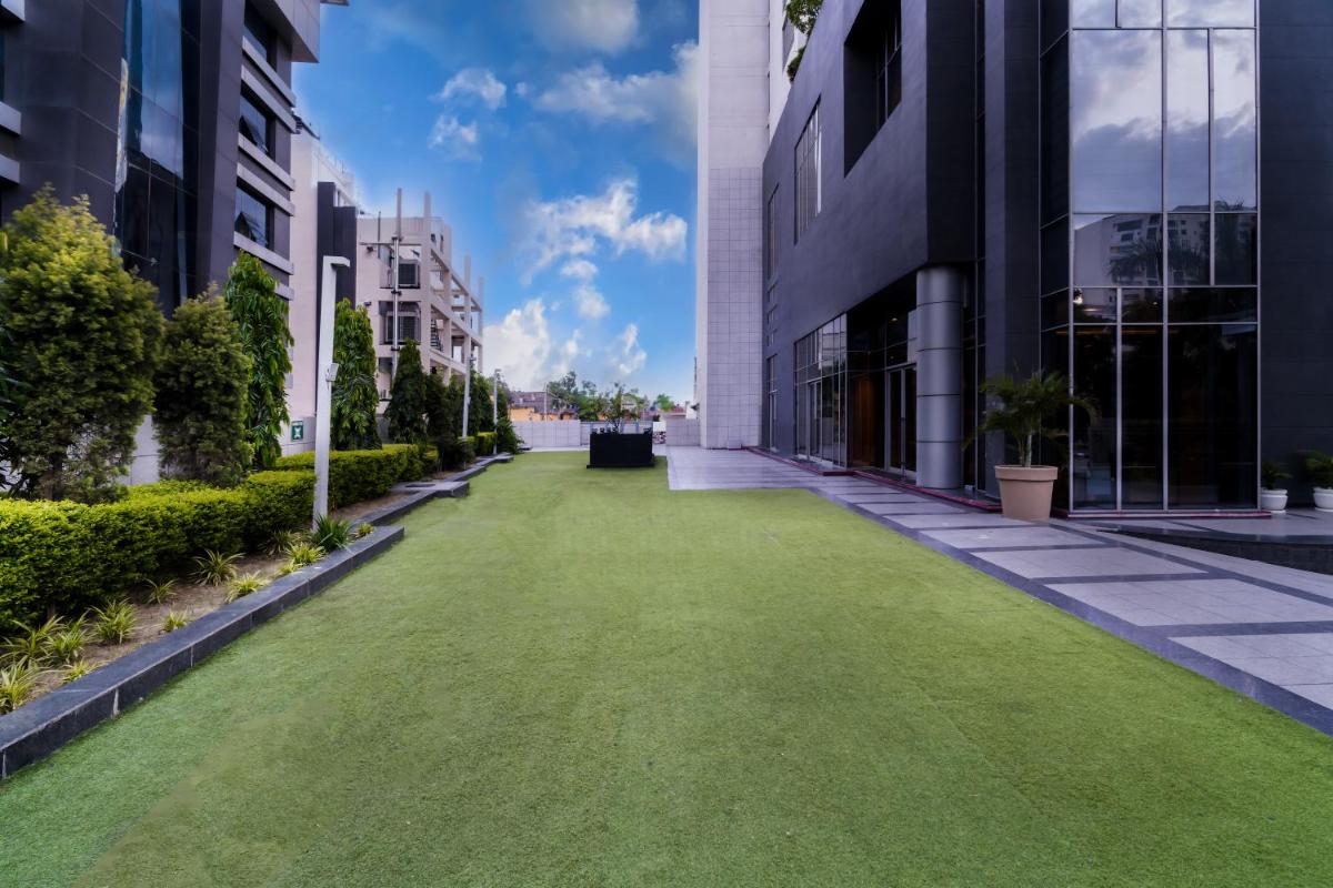 a lawn in the middle of a street between buildings at Hyatt Regency Lucknow Gomti Nagar in Lucknow