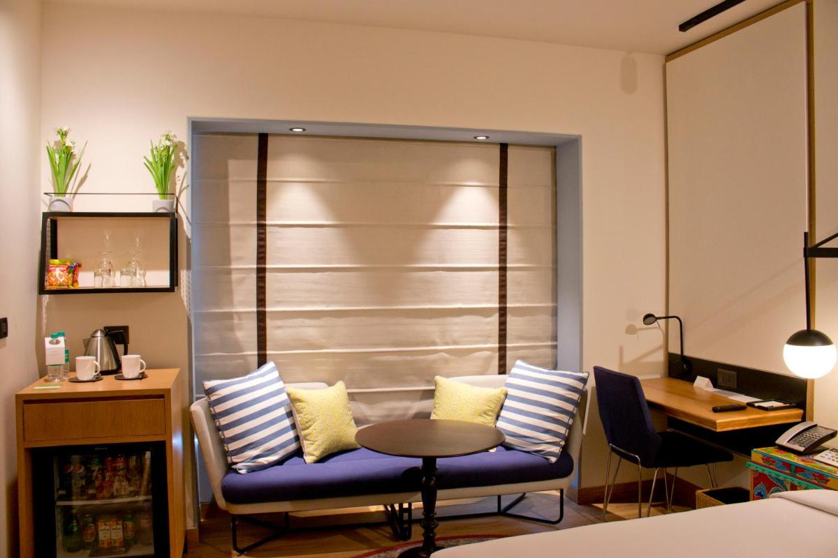 a living room with a blue couch and a table at Hyatt Centric MG Road Bangalore in Bengaluru a living room with a blue couch and a table at Hyatt Centric MG Road Bangalore in Bengaluru