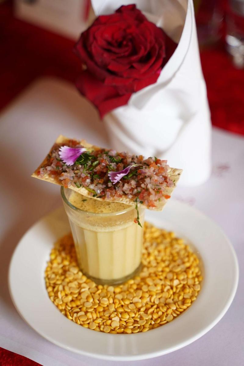a dessert with a slice of pizza on a plate with a rose at Radisson Blu Hotel, Greater Noida in Greater Noida