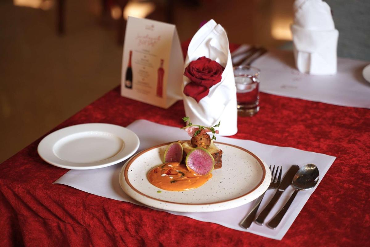a table with a plate of food on a table at Radisson Blu Hotel, Greater Noida in Greater Noida