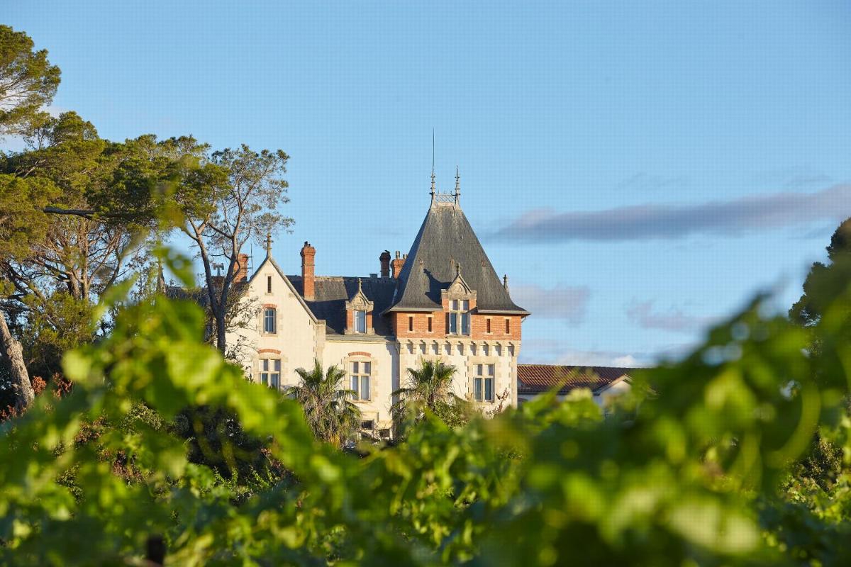 une maison ancienne avec un toit en haut dans l'établissement Château St Pierre de Serjac, à Puissalicon