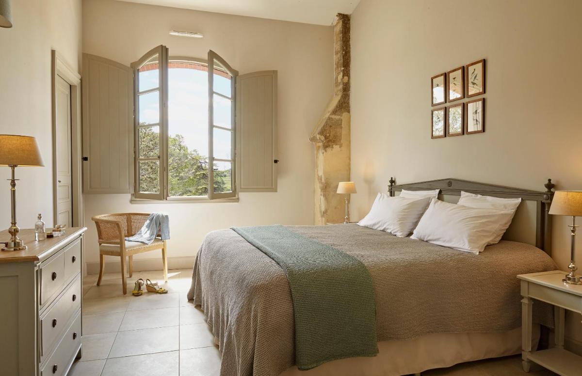 une chambre avec un lit et une fenêtre dans l'établissement Château St Pierre de Serjac, à Puissalicon