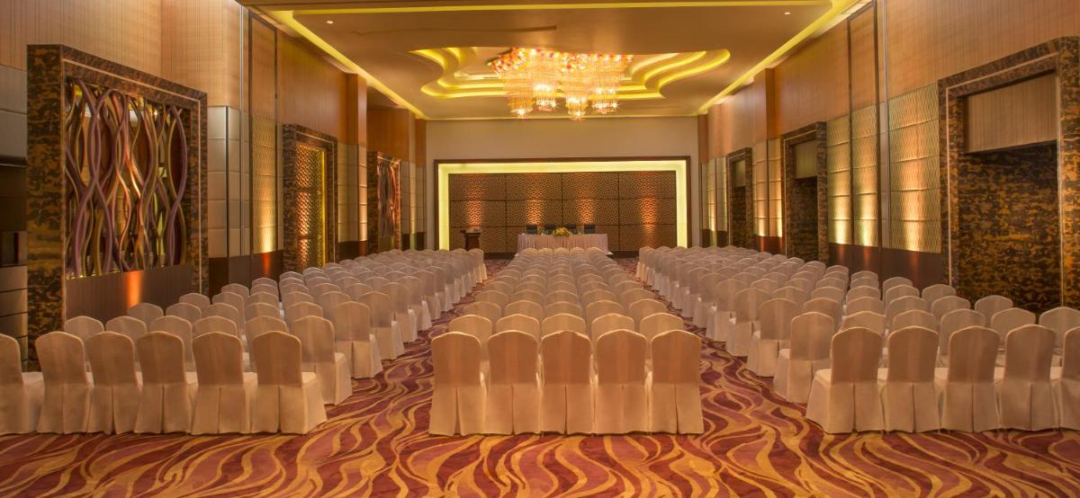 a banquet hall with rows of chairs and a chandelier at Radisson Blu Hotel, Indore in Indore