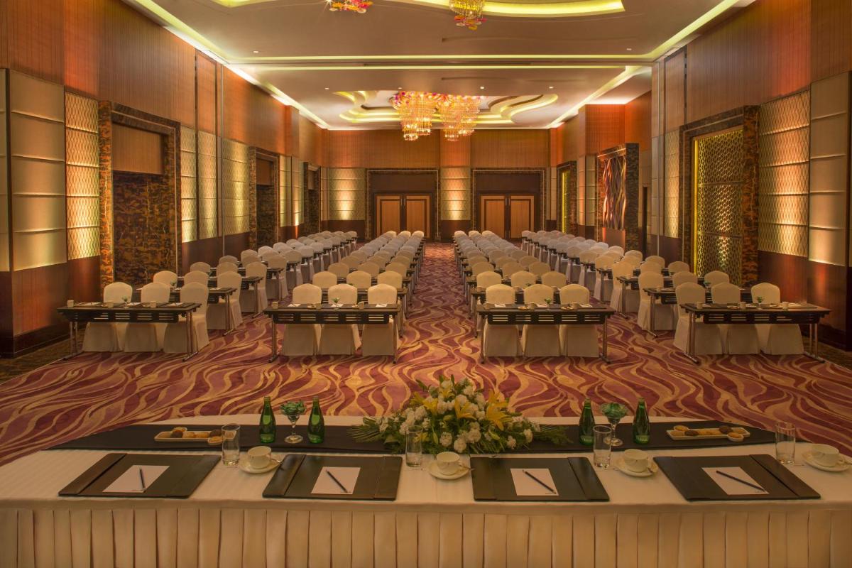 a banquet hall with rows of tables and chairs at Radisson Blu Hotel, Indore in Indore