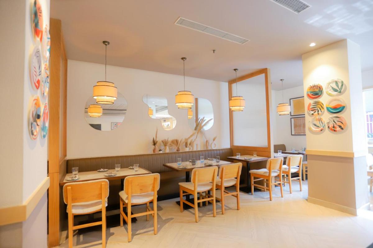a dining room with tables and chairs and lights at Park Inn by Radisson,South Delhi in New Delhi a dining room with tables and chairs and lights at Park Inn by Radisson,South Delhi in New Delhi