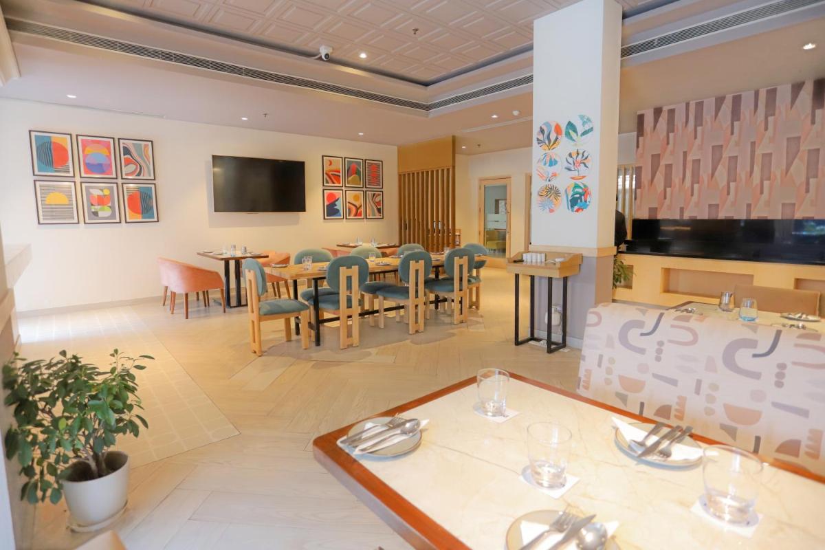a dining room with a table and chairs at Park Inn by Radisson,South Delhi in New Delhi a dining room with a table and chairs at Park Inn by Radisson,South Delhi in New Delhi
