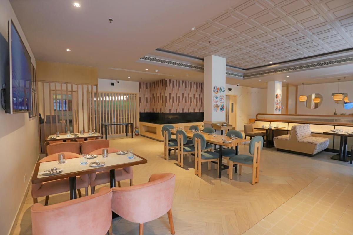 a restaurant with tables and chairs and a couch at Park Inn by Radisson,South Delhi in New Delhi a restaurant with tables and chairs and a couch at Park Inn by Radisson,South Delhi in New Delhi