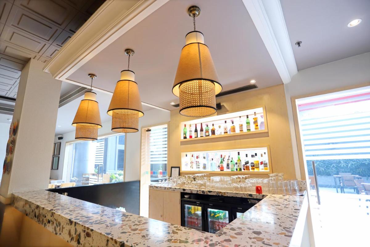 a bar in a restaurant with several lights at Park Inn by Radisson,South Delhi in New Delhi a bar in a restaurant with several lights at Park Inn by Radisson,South Delhi in New Delhi