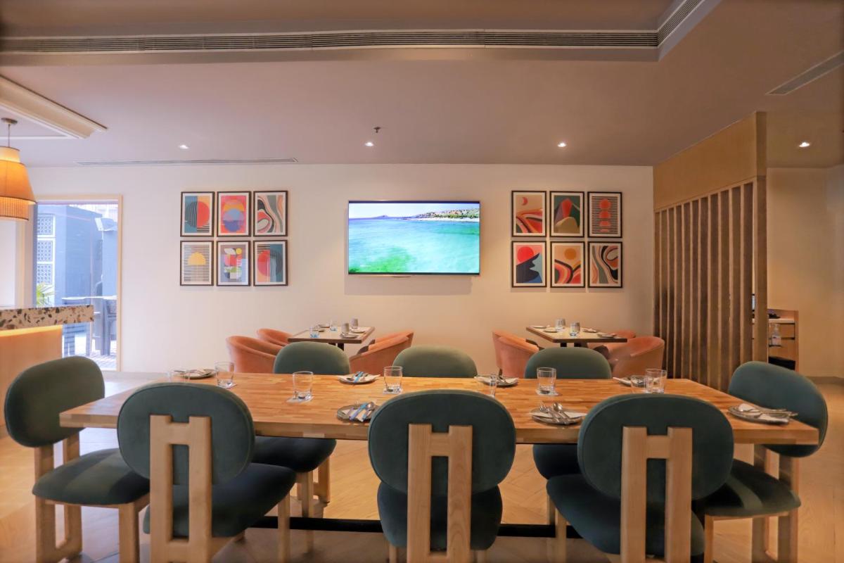 a dining room with a large wooden table and chairs at Park Inn by Radisson,South Delhi in New Delhi a dining room with a large wooden table and chairs at Park Inn by Radisson,South Delhi in New Delhi