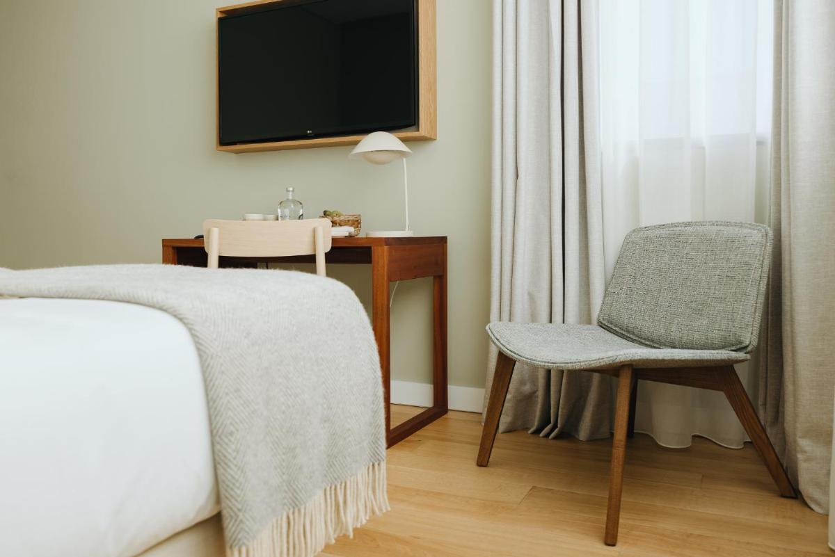 um quarto com uma secretária, uma cadeira e uma televisão em NINE DOTS Azorean Art Boutique Hotel em Ponta Delgada