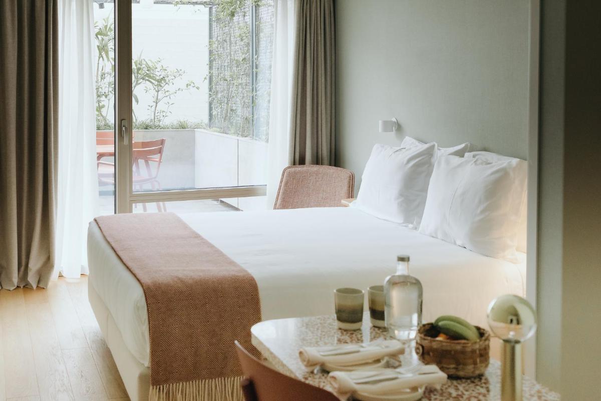 um quarto de hotel com uma cama e uma mesa com toalhas em NINE DOTS Azorean Art Boutique Hotel em Ponta Delgada