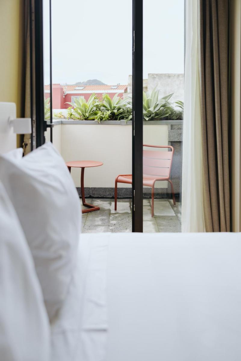 Uma cama ou camas num quarto em NINE DOTS Azorean Art Boutique Hotel