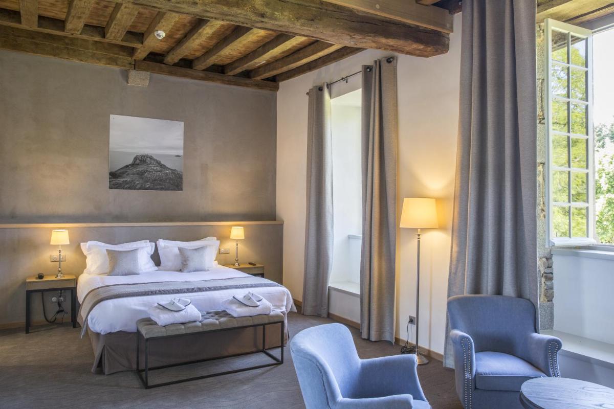une chambre d'hôtel avec un lit et deux chaises dans l'établissement Hotel de L'Abbaye Le Tronchet - Handwritten Collection, au Tronchet
