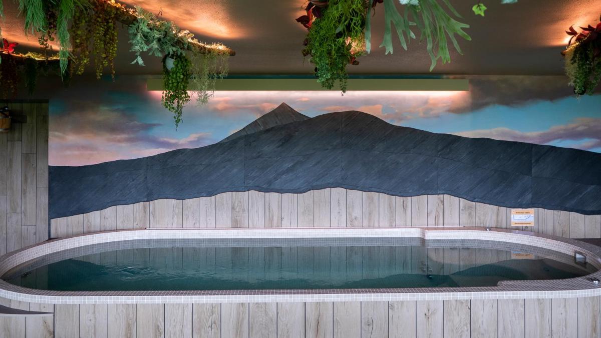 une piscine avec une fresque représentant une montagne dans l'établissement Logis Hôtel Restaurant & Spa les Remparts, à Salers