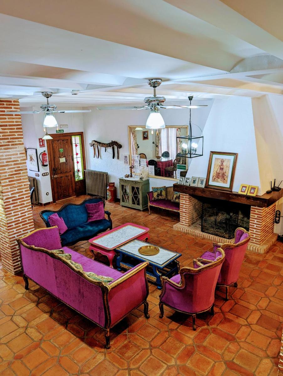 sala de estar con muebles de color púrpura y chimenea en Casa El Descanso Del Peregrino, en Guadalupe