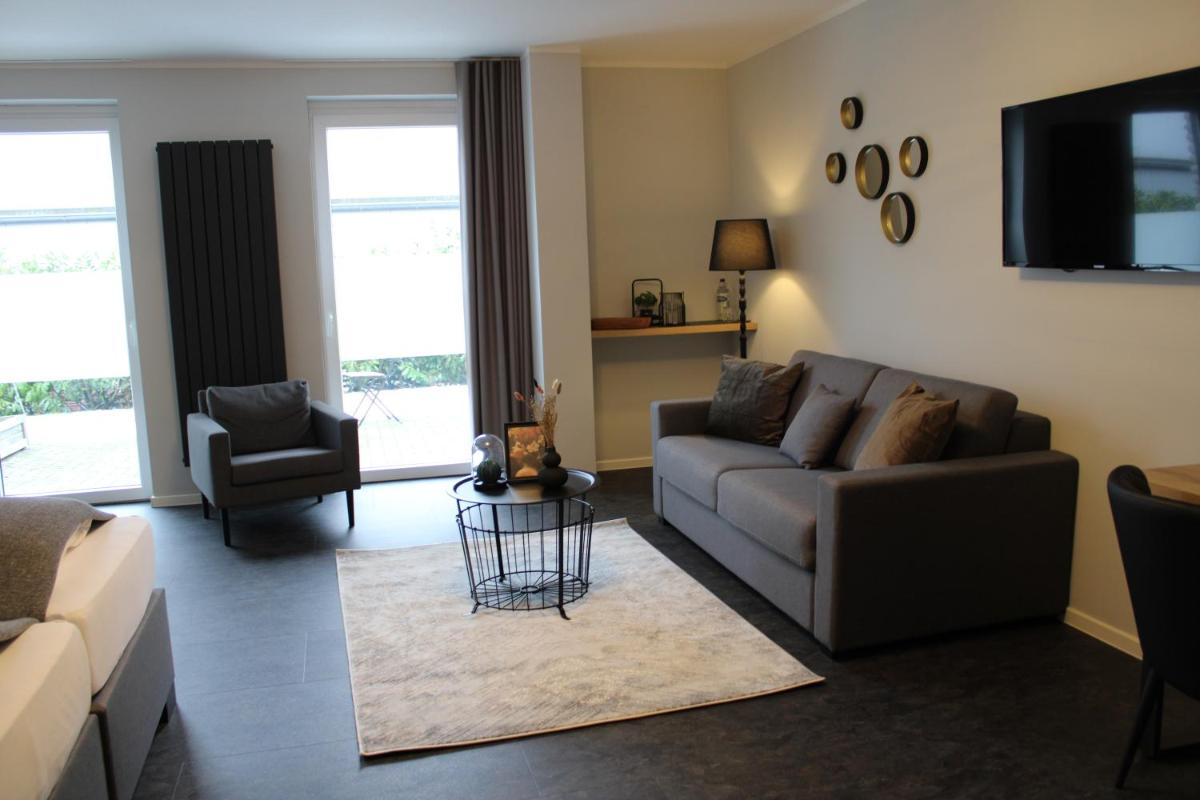 ein Wohnzimmer mit Couch und Tisch in der Unterkunft Motel Hasetal in Löningen