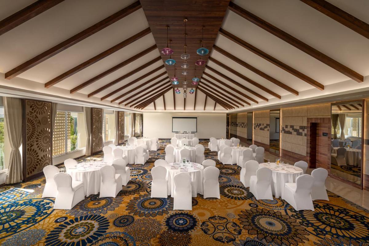 a banquet hall with white tables and white chairs at Hawthorn Suites by Wyndham Dwarka in Dwarka +125 photos a banquet hall with white tables and white chairs at Hawthorn Suites by Wyndham Dwarka in Dwarka +125 photos