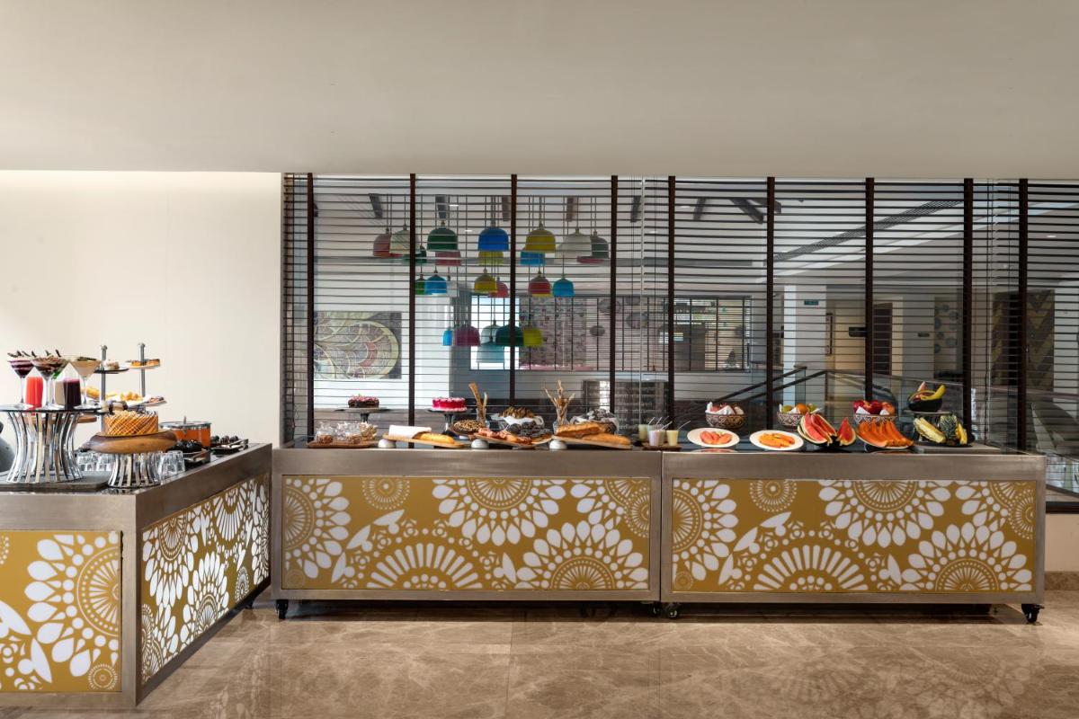 a kitchen with a buffet with a lot of food at Hawthorn Suites by Wyndham Dwarka in Dwarka a kitchen with a buffet with a lot of food at Hawthorn Suites by Wyndham Dwarka in Dwarka