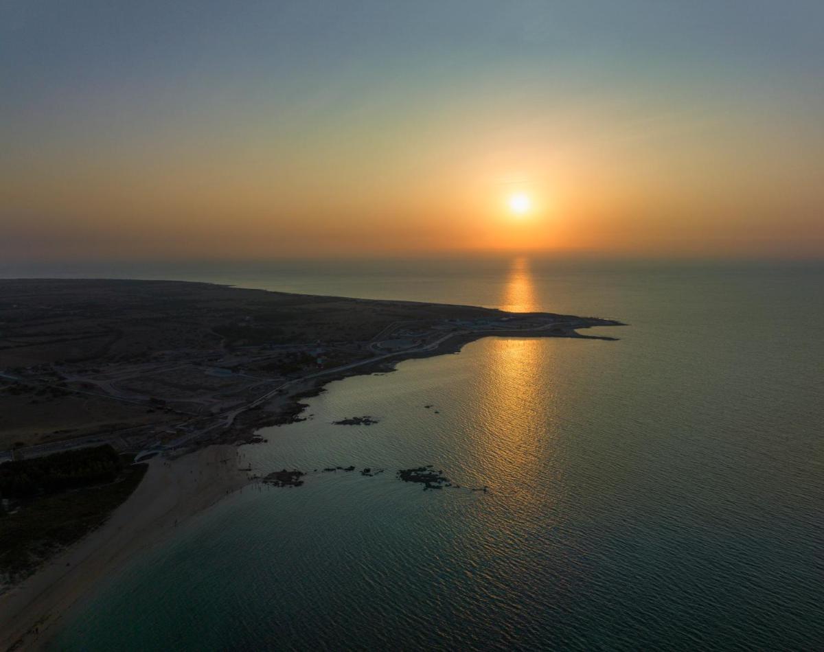 an aerial view of the sun setting over the ocean at Hawthorn Suites by Wyndham Dwarka in Dwarka an aerial view of the sun setting over the ocean at Hawthorn Suites by Wyndham Dwarka in Dwarka