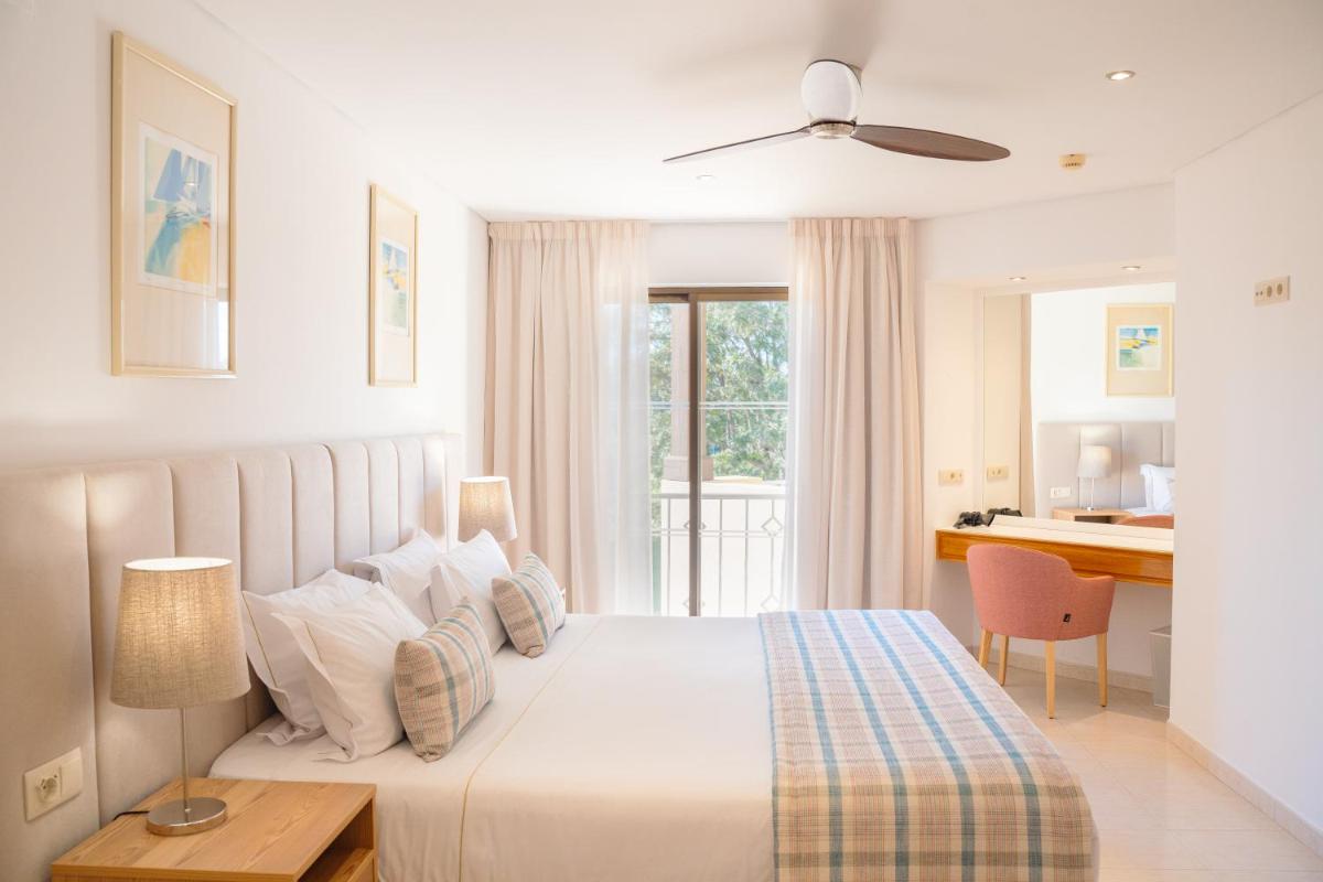 um quarto branco com uma cama e uma secretária em Four Seasons Vilamoura em Vilamoura