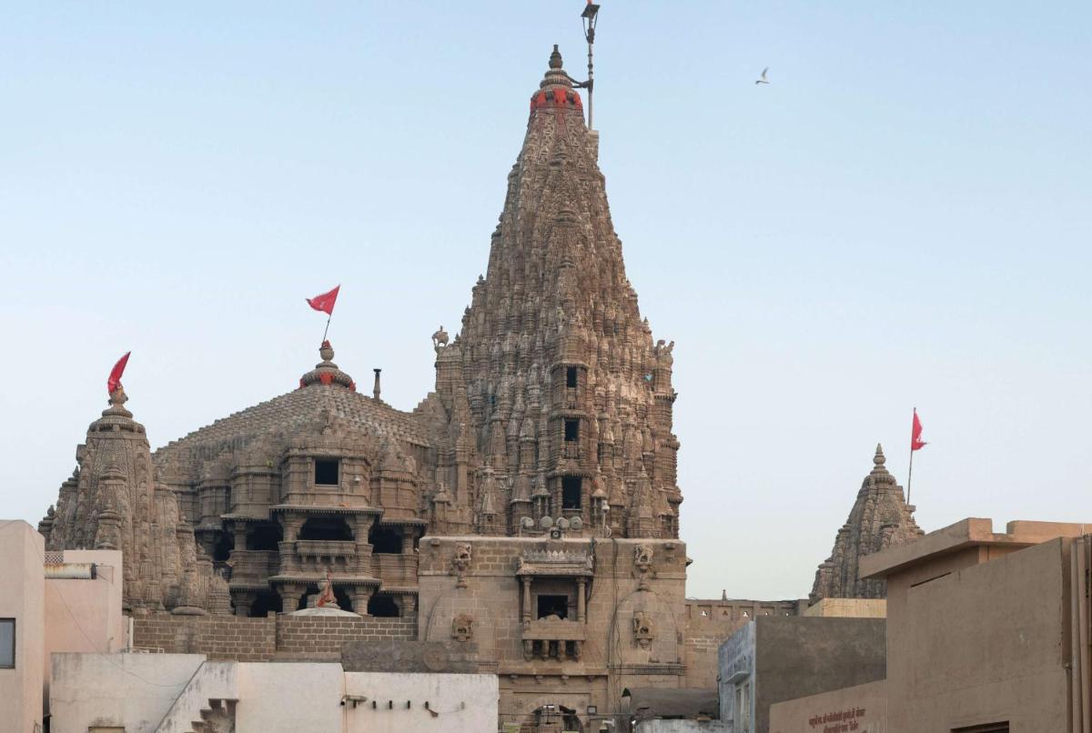 a large stone building with flags on top of it at Hawthorn Suites by Wyndham Dwarka in Dwarka a large stone building with flags on top of it at Hawthorn Suites by Wyndham Dwarka in Dwarka