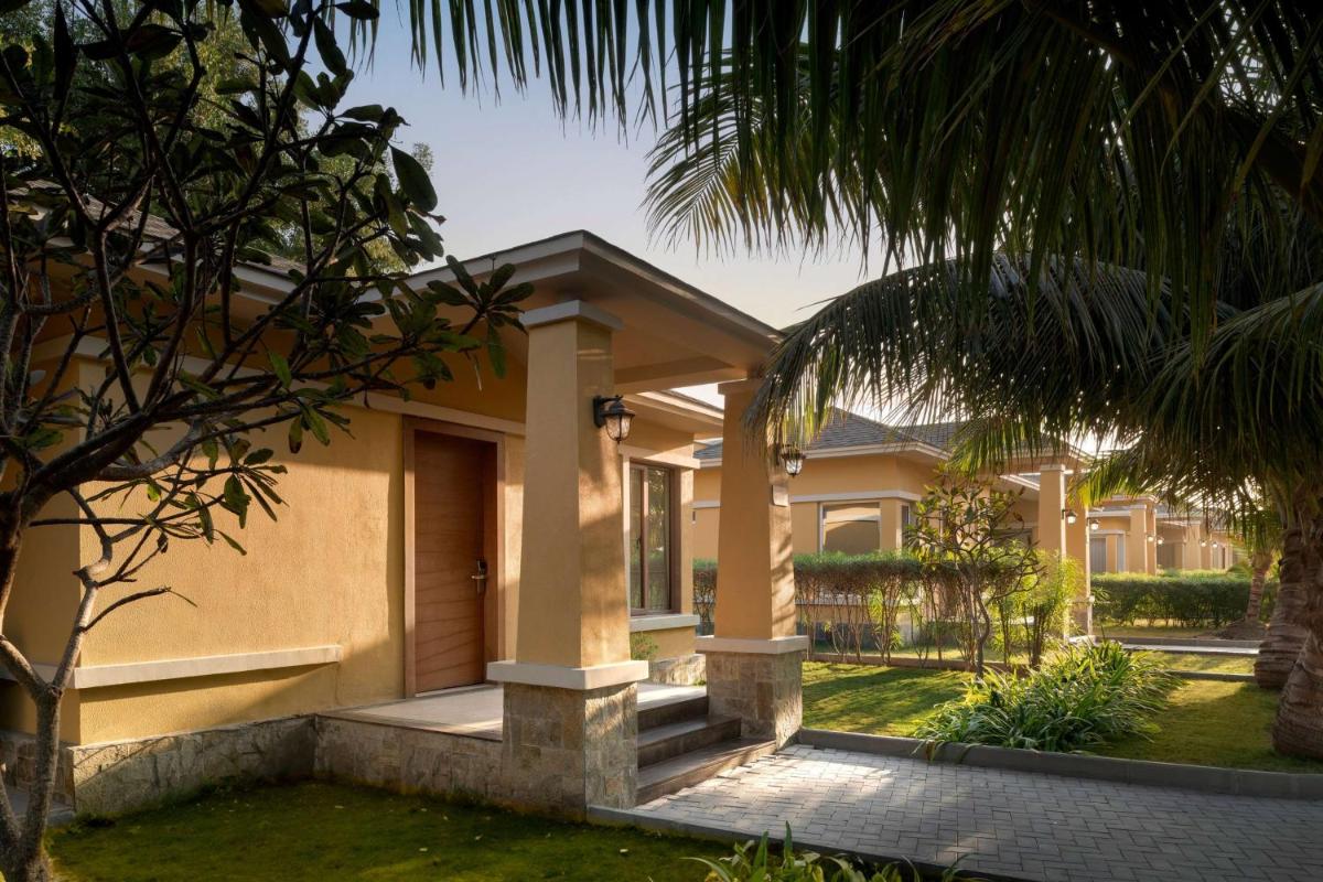 a house with a palm tree in front of it at Hawthorn Suites by Wyndham Dwarka in Dwarka a house with a palm tree in front of it at Hawthorn Suites by Wyndham Dwarka in Dwarka