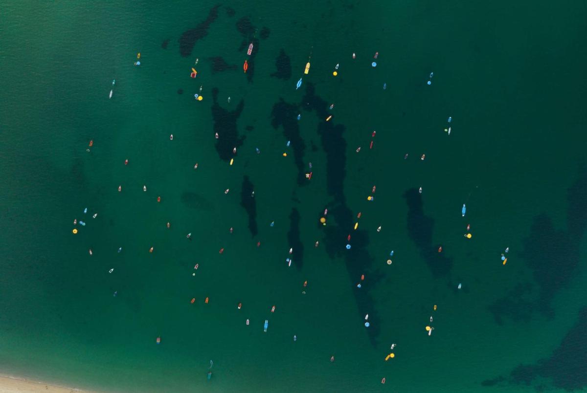 a group of people standing in the water at night at Hawthorn Suites by Wyndham Dwarka in Dwarka a group of people standing in the water at night at Hawthorn Suites by Wyndham Dwarka in Dwarka