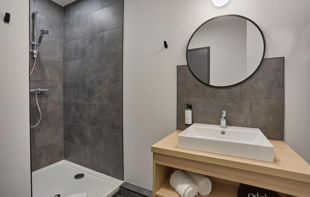 une salle de bains avec un lavabo et un miroir dans l'établissement Appart'hôtel Odalys City - Nîmes Arènes - Palais des Congrès, à Nîmes