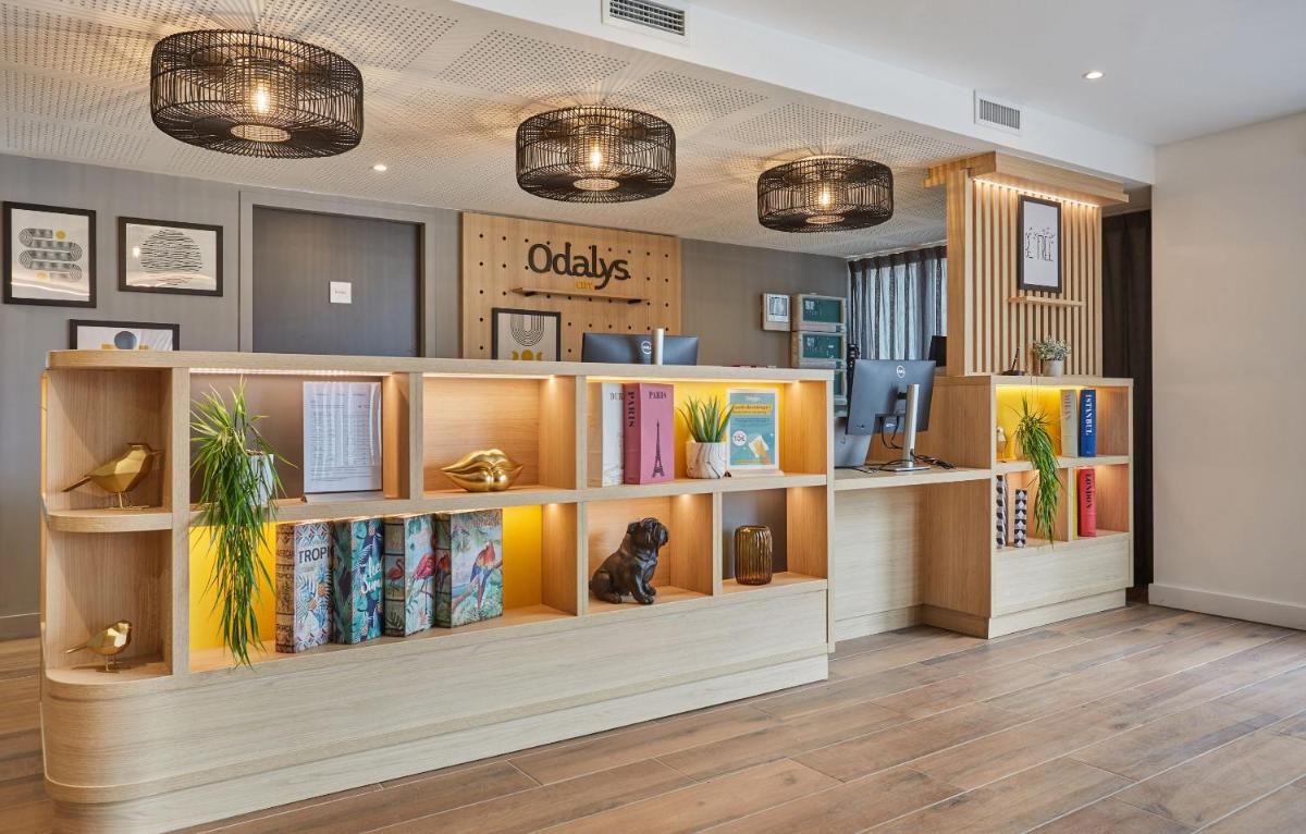une bibliothèque avec des étagères remplies de livres dans l'établissement Appart'hôtel Odalys City - Nîmes Arènes - Palais des Congrès, à Nîmes