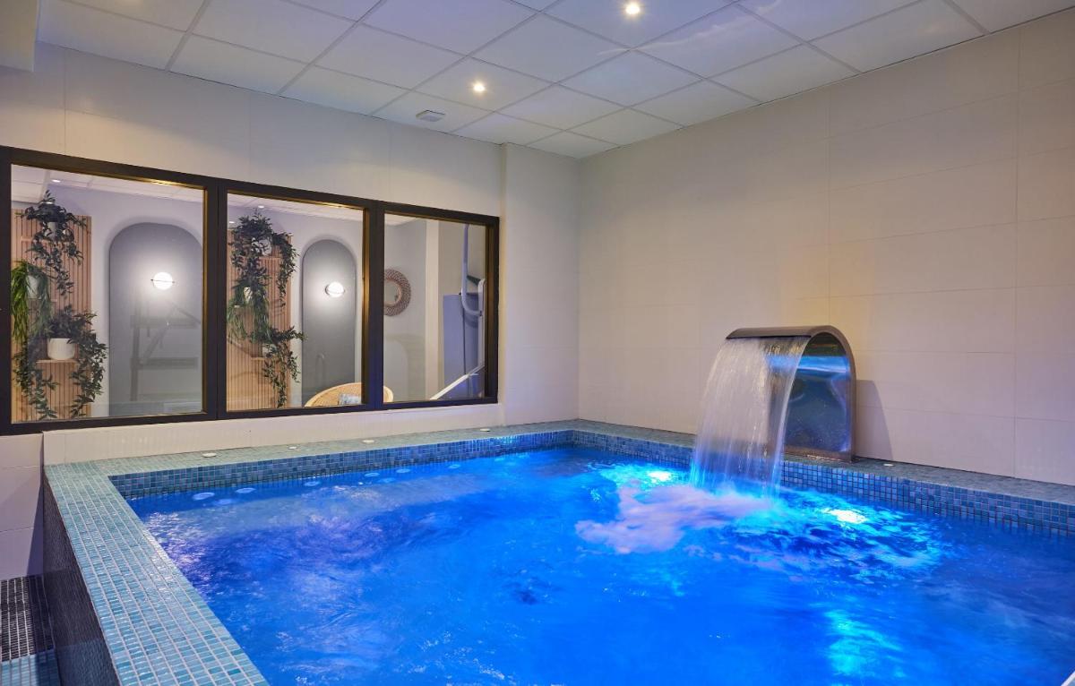 une piscine avec une cascade dans une chambre dans l'établissement Appart'hôtel Odalys City - Nîmes Arènes - Palais des Congrès, à Nîmes
