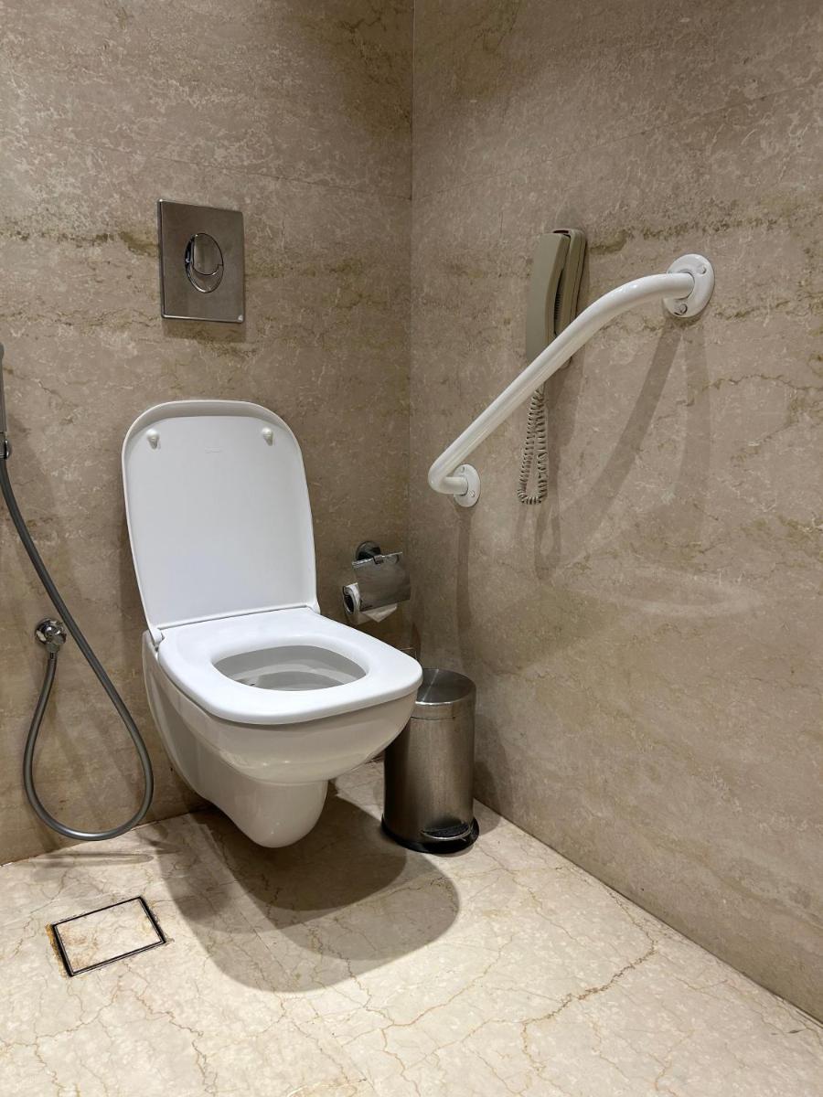 a bathroom with a toilet and a shower at Ramada Plaza by Wyndham Lucknow in Lucknow