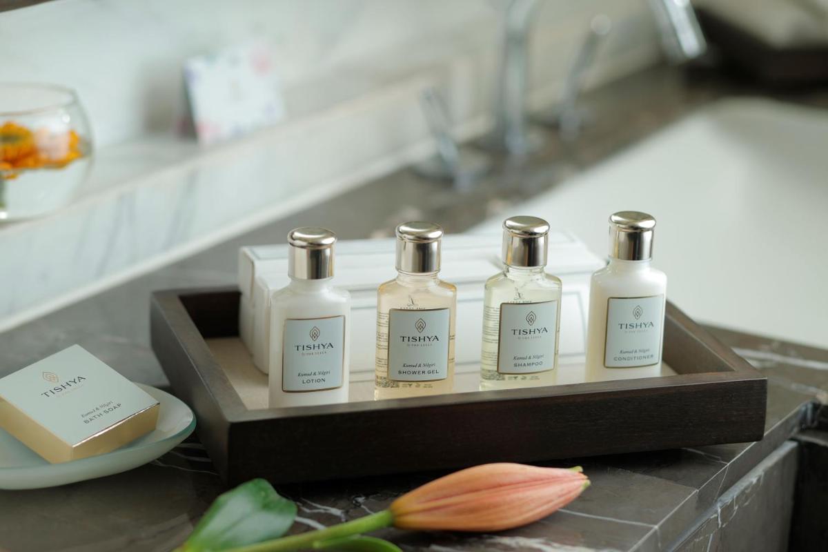 a group of four bottles of soap on a counter at The Leela Ambience Convention Hotel Delhi in New Delhi
