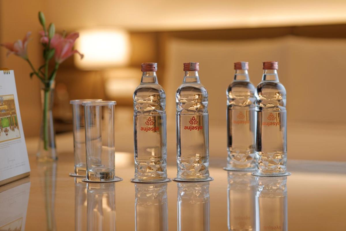 a group of four bottles and glasses on a table at The Leela Ambience Convention Hotel Delhi in New Delhi