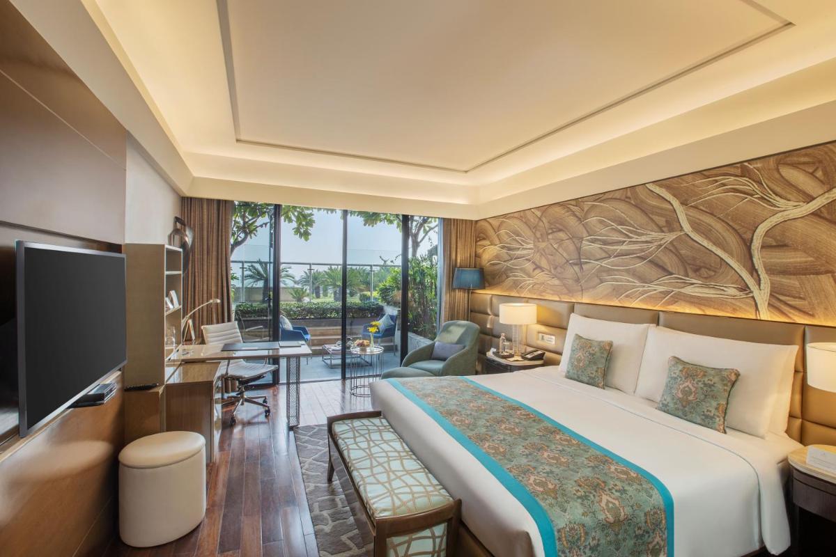 a hotel room with a bed and a tv at The Leela Ambience Convention Hotel Delhi in New Delhi